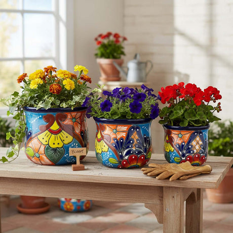 The Talavera Hub set of 3 ceramic flower pots, hand-painted with vibrant blue, orange, yellow, and red floral designs.