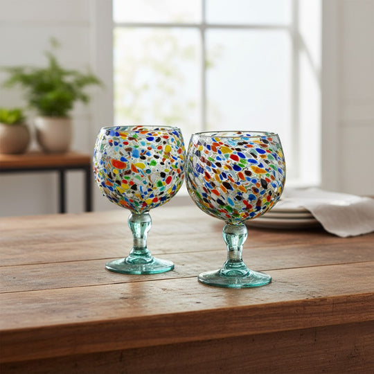 The Talavera Hub large fish bowl margarita glasses with colorful confetti pebble design, made from lead-free recycled glass.