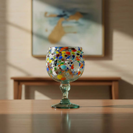 The Talavera Hub oversized fish bowl margarita glass with colorful confetti pebble design. Hand-blown recycled glass, 23 oz.