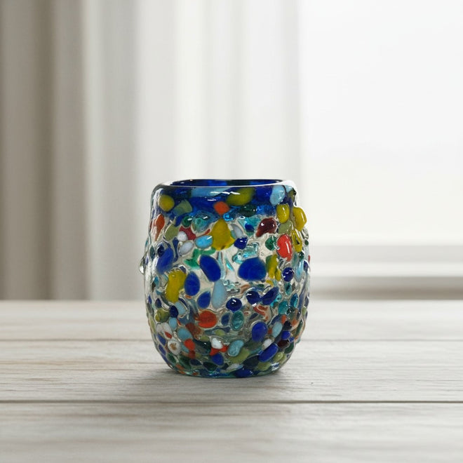 The Talavera Hub Confetti Rimmed Shot Glass with blue rim and multicolor glass flecks. Hand-blown recycled glass.