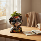 The Talavera Hub hand-painted ceramic Day of the Dead skull girl planter with blue eyes, flower details, and skeleton design.
