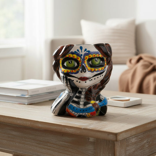 The Talavera Hub hand-painted ceramic Day of the Dead skull girl planter with green eyes and braided hair.