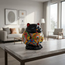 The Talavera Hub handmade black ceramic fat cat planter with vibrant floral patterns and blue eyes.