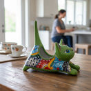The Talavera Hub green ceramic cat planter with hand-painted floral designs in blue, red, and yellow.