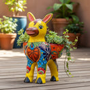 The Talavera Hub hand-painted ceramic donkey planter in yellow with colorful floral and geometric Talavera designs. Features two openings for plants.