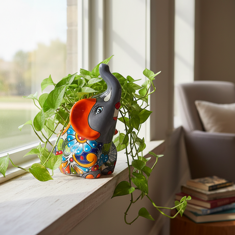 The Talavera Hub handmade gray elephant planter with colorful floral Talavera design and orange accents.