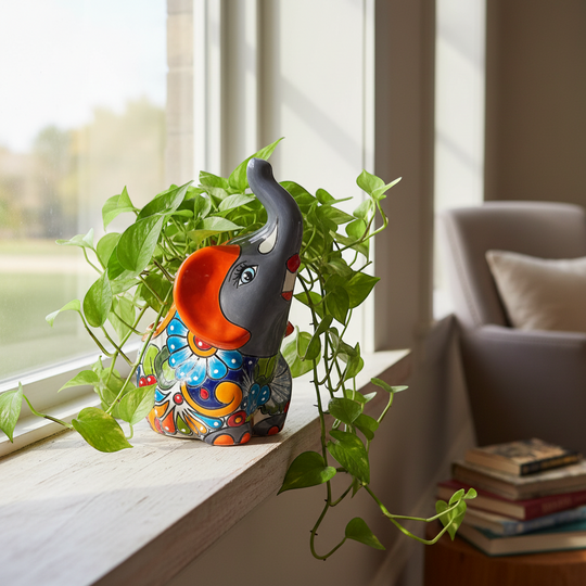 The Talavera Hub handmade gray elephant planter with colorful floral Talavera design and orange accents.