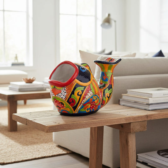 The Talavera Hub hand-painted ceramic fish planter in vibrant orange, green, yellow, red, and blue with floral motifs.