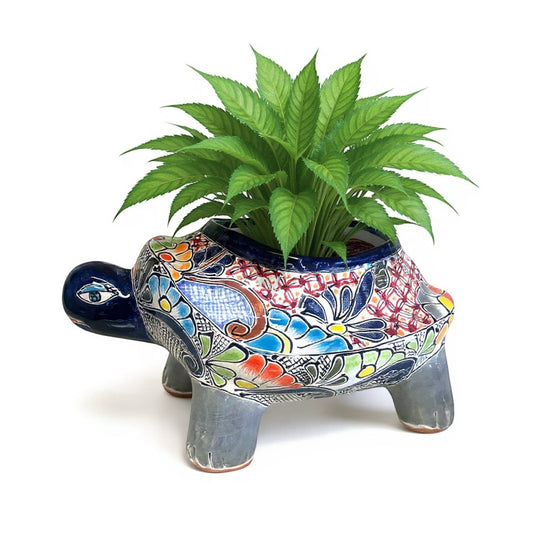 The Talavera Hub hand-painted ceramic turtle planter with colorful floral designs and a dark blue rim.
