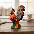 The Talavera Hub hand-painted ceramic rooster statue with floral details in orange, yellow, red, blue, and green.