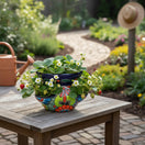 The Talavera Hub hand-painted ceramic strawberry planter with floral patterns in blue, green, red, and orange.