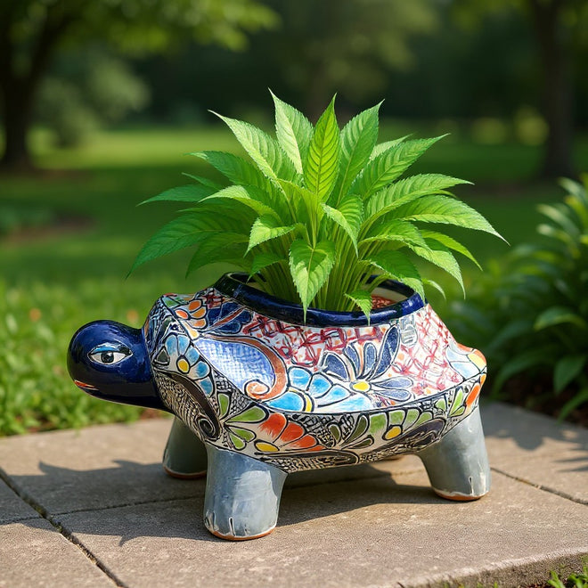 The Talavera Hub hand-painted ceramic turtle planter with colorful floral and geometric designs. Features a dark blue rim and grey legs.