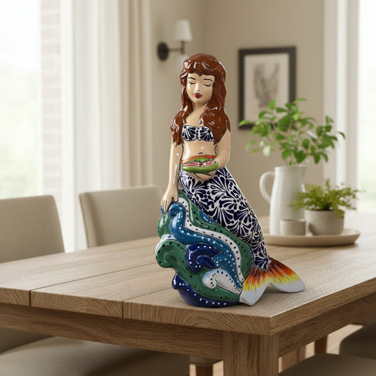 The Talavera Hub hand-painted ceramic mermaid figurine with floral tail, holding a fish. Coastal decor.