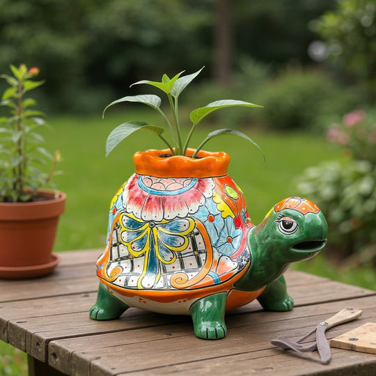 The Talavera Hub medium hand-painted ceramic turtle planter with vibrant floral and bow details. Features a green head and orange rim.