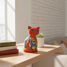 The Talavera Hub hand-painted orange ceramic cat statue with blue, yellow, and floral designs. Medium size.