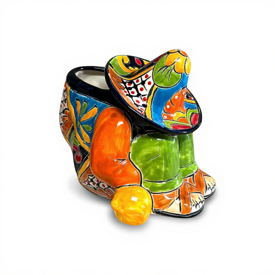 The Talavera Hub colorful ceramic planter shaped like a sleeping man in a sombrero, hand-painted with orange, blue, green, and red.