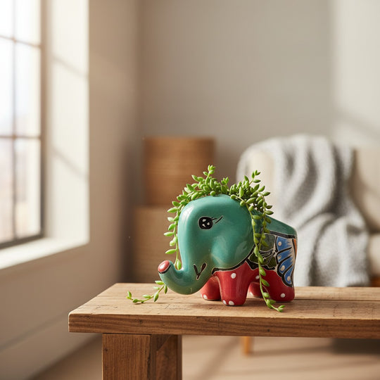 The Talavera Hub hand-painted ceramic elephant planter in teal with red, blue, and green floral details. Small size for succulents.