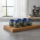 The Talavera Hub Confetti Rimmed Shot Glass with blue rim and multicolor confetti glass. Hand-blown recycled glass.